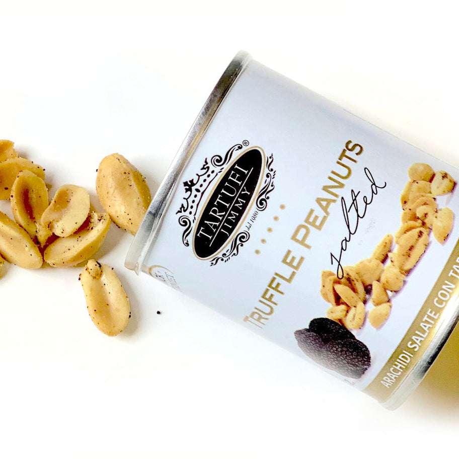 Salted truffle peanuts spilling from a can on a white background
