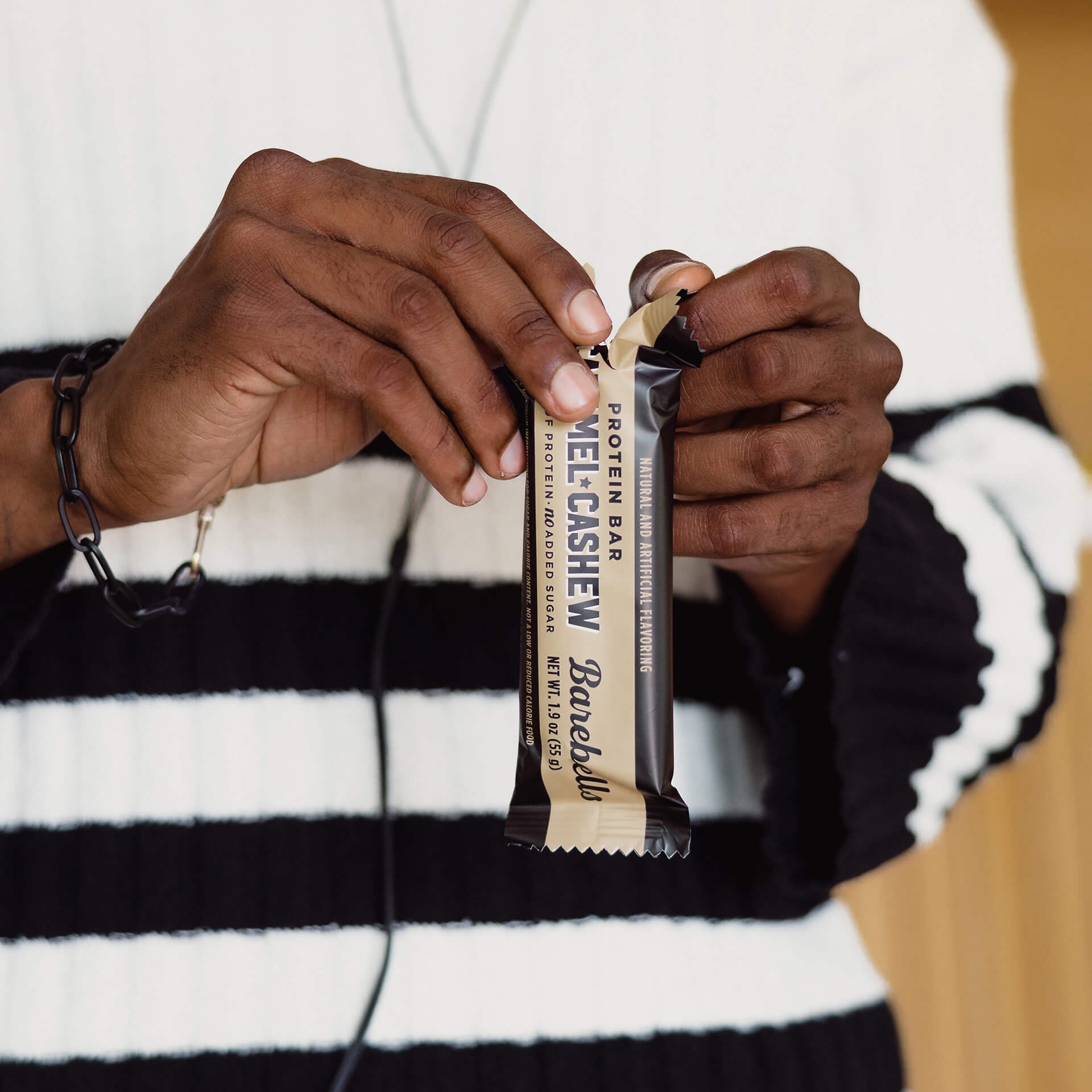 Person holding a chocolate bar with a white and black striped shirt