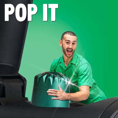 Man in green shirt excitedly opening large green cap under text 'POP IT' with bright background.