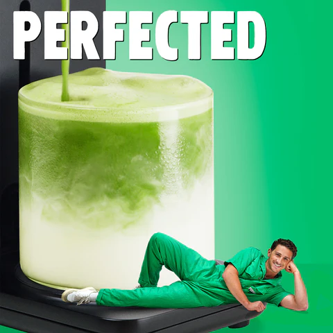 Creamy iced matcha latte in clear glass with swirling green tea, person in green outfit posing in front